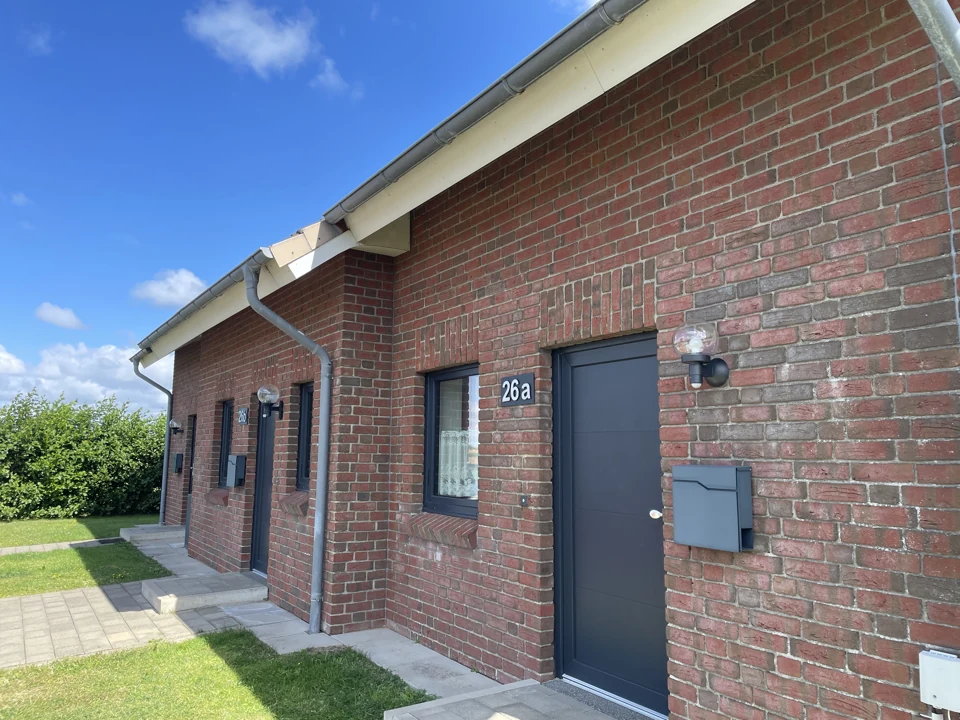 Backsteinfassade mit Eingang und Fenster von Wohnung A